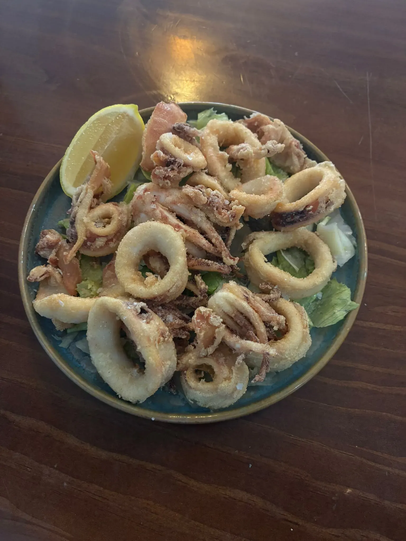 Calamares fritos con limón sobre lechuga