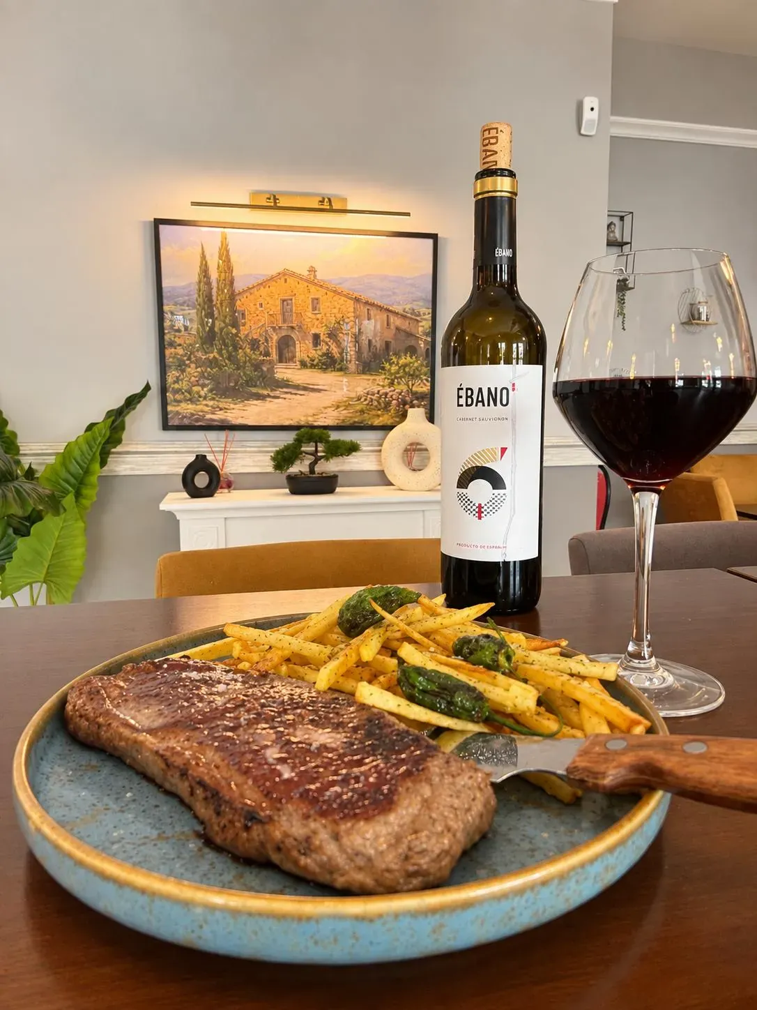 Entrecote de vaca pajuna con patatas y pimientos, con una copa de tinto